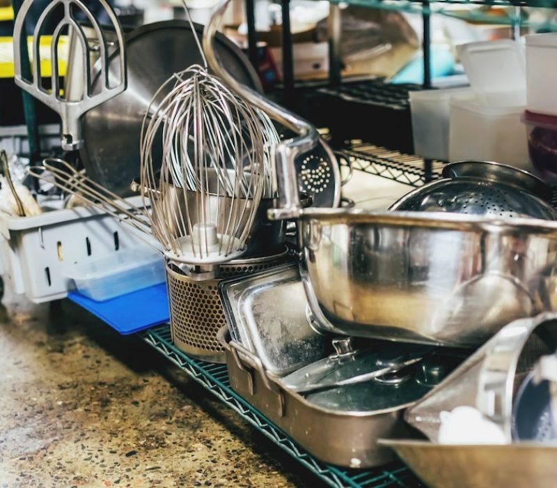 Kitchen utensils on shelves in an industrial kitchen.